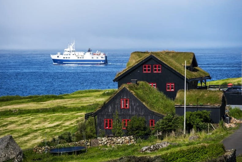 Kirkjubøur typical house with ship on backdrop